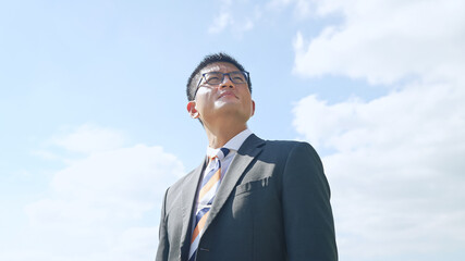 空を見上げるビジネスマン