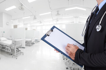 Doctor recording on clipboard for diagnosis disease at aided the recovery room with modern...