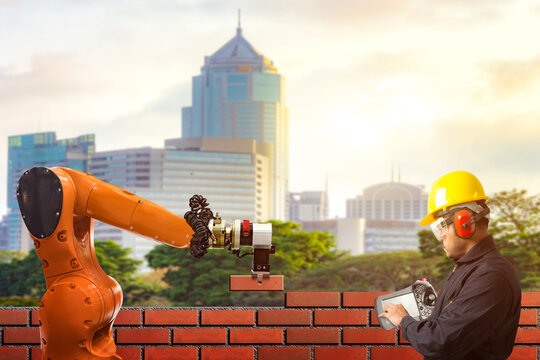 Engineer control working of bricklayer robot working for building brick wall at building construction site .concept of robotic technologies in construction industry.