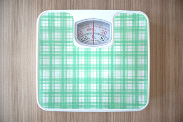 Fitness and weight loss concept, weight scales on wood floor in the gym