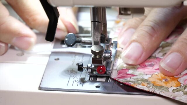 Slow motion speed closeup scene on designer hand that moving cloth for sew by electric sewing machine, beautiful design diy protective mask trend in covid-19 pandemic period.
