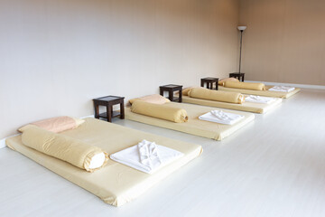 Interior of massage room in spa saloon consisting of bench pillows towels