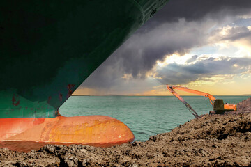 An excavator attempts to free stranded container ship, largest container ships, after it ran...