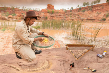 Archeologist works on an archaeological site with in sieve used for screening in dinosaur skeleton on stone fossil excavations.
