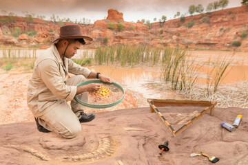 Archeologist works on an archaeological site with in sieve used for screening in dinosaur skeleton...