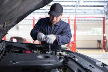 Obraz na płótnie Canvas Professional car mechanic working in maintenance repair service station