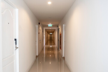 Long corridor in luxury condominium. inside the apartment building has signs and fire escape doors...