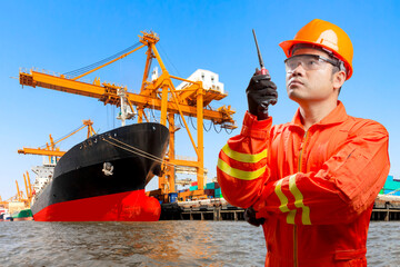  dock worker with radio communication in action for controlling work process commercial ship loading container in shipping port export nautical vessel transport and industry logistic in the harbor