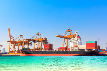 Obraz premium Cargo ship loading containers at commercial harbor