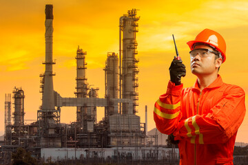 Engineer with radio communication in action for working at petrochemical oil refinery in beautiful...