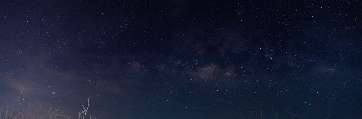 Obraz premium Panorama blue night sky milky way and star on dark background.Universe filled with stars, nebula and galaxy with noise and grain.Photo by long exposure and select white balance.selection focus.amazing