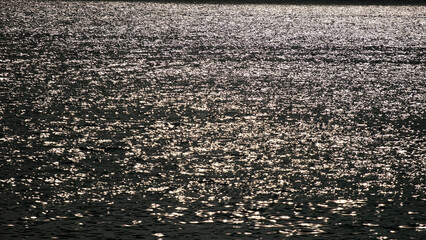Aerial view Texture of dark sea surface with small waves in the sea and Beautiful light sunset or sunrise over sea surface dark sea texture background