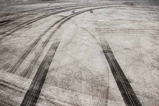Tire marks on race track with turning black tire tracks over concrete road pavement