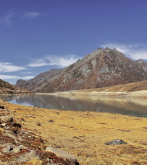 beautiful sela lake, alpine meadow and rocky mountain peak at sela pass, tawang in arunachal pradesh in north east india