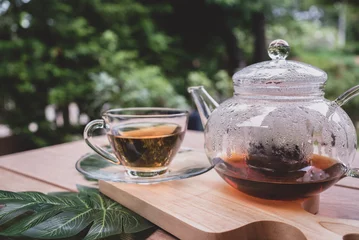 Foto auf Acrylglas black hot tea in teacup served on table in cafe © plo