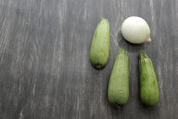Fresh and freshly harvested vegetables like green squash and onion ready as ingredients for cooking

