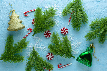 Branches of the Christmas tree Christmas decorations candy and snowflakes on a blue background