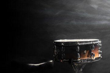 Snare drum on a black background with stage lighting, copy space.