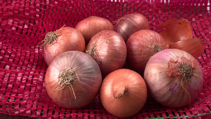 Fresh red onions in a wooden bowl.