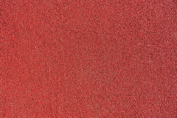 Red rubber coating made of recycled rubber chips on the sports field.Top view