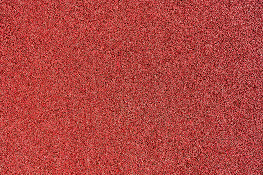 Red rubber coating made of recycled rubber chips on the sports field.Top view