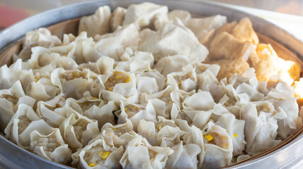 pile of dumplings in a steaming pot with steaming steam. healthy traditional food dumplings, tofu and fish balls