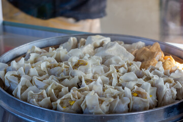 pile of dumplings in a steaming pot with steaming steam. healthy traditional food dumplings, tofu and fish balls