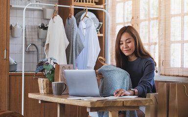 A female entrepreneur selling clothes and checking orders from customer for online shopping concept