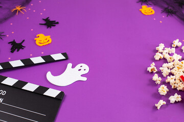 Movie Clapper board in spider webs, spiders, ghost, eyes on purple Lilac Background.