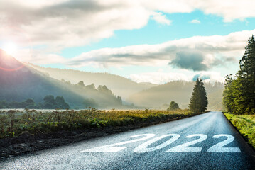 road on which is written 2022 at sunrise in the mountains ilis.beginning 2022. morning fog near the...
