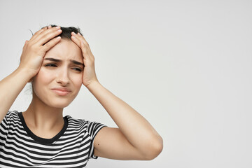 woman in a striped t-shirt pain in the neck light background