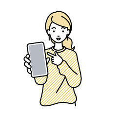 立ってスマートフォンを指差してこちらに向けて見せているリモートワークの女性