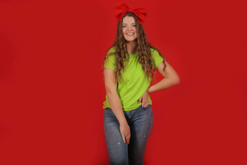 a young beautiful girl with long hair with a red bow on her head in a light green T-shirt in blue...