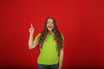 a young beautiful girl with long hair in a light green T-shirt in blue jeans shows emotion