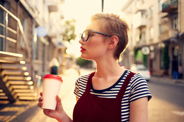 woman with short hair outdoors wearing glasses walking in summer