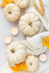 Obraz na płótnie Canvas Autumn setting with white pumpkins, fall leaves and burning candles. Thanksgiving concept