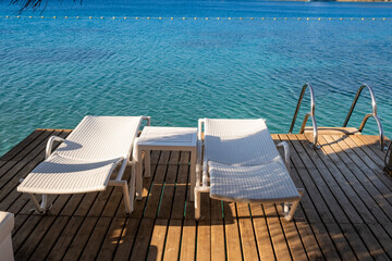 empty sunbeds on the sea shore, top view