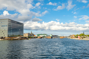 Naklejka premium Beautiful modern buildings on the bank of the canal in Copenhagen, Denmark. Beautiful clouds. Contemporary European architecture. Architecture.