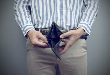 A man holding an empty wallet with his hands, Bankruptcy, unemployment, poverty concept.