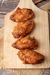 Hot and spicy Korean barbeque fried chicken on wood cutting board