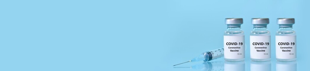 Three vials with a vaccine, a syringe on a blue background.The concept of medicine, healthcare and science.Coronavirus vaccine.Copy space for text..Banner