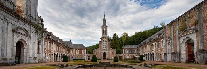 Panorama des bâtiments principaux de l'abbaye d'Aulne sous un ciel gris menaçant