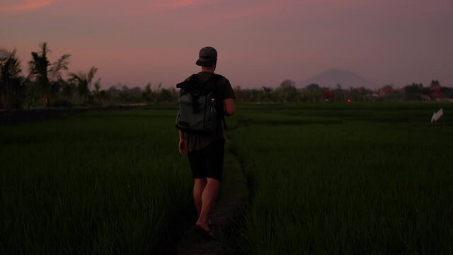 Handsome male traveler walking on evening dusk in nature environment making video for share in social networks on mobile phone, man explorer influencer taking picture of environment on cellular
