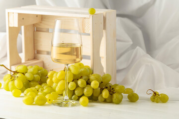 Glass of white wine and grape cluster.