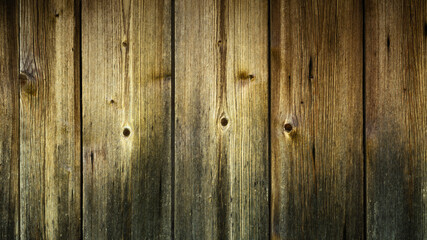 a dark wooden grunge background or backdrop from old used planks that are naturally worn out. moody artistic mockup for creative design