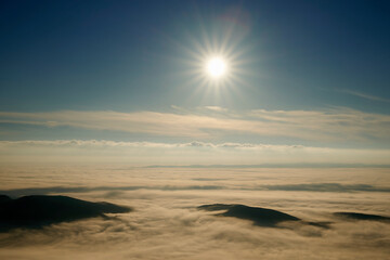 Sunrise in the alps over clouds and fog