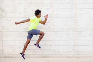 Black man training running jumps to strengthen his legs.