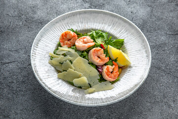 Hearty salad with shrimps, tomatoes, lettuce, sauce. Diet food. Ready menu for the restaurant. Neutral gray blue textured background