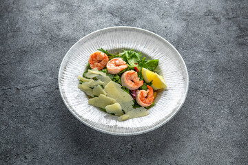 Hearty salad with shrimps, tomatoes, lettuce, sauce. Diet food. Ready menu for the restaurant. Neutral gray blue textured background