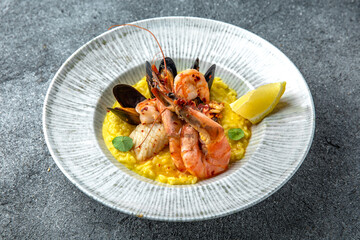 Risotto of seafood in champagne. Shrimps, mussels, squid. Ready menu for the restaurant. Neutral gray blue textured background